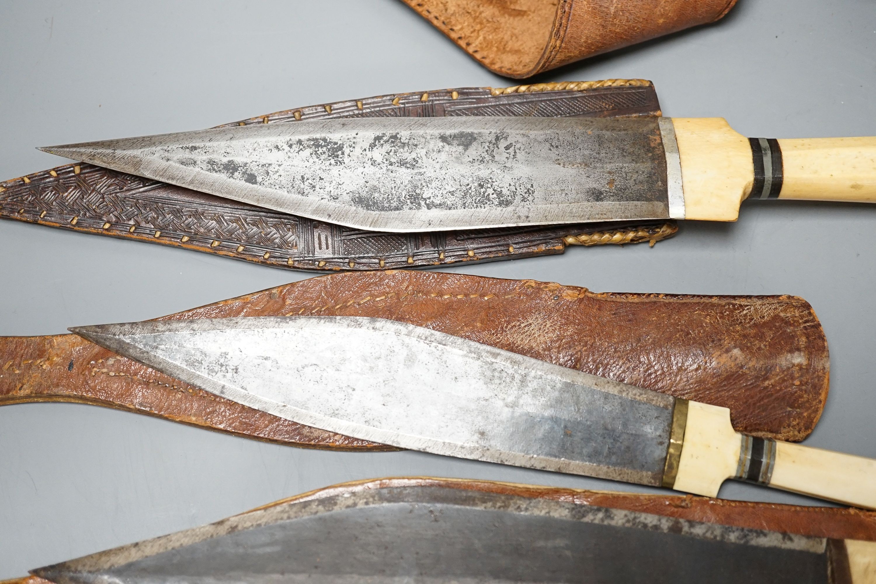 Four similar African tribal daggers c.1900, each with hippo tusk handle including two with silver pommels, all in their decorated leather scabbards with 1 belt, maximum 45cms.